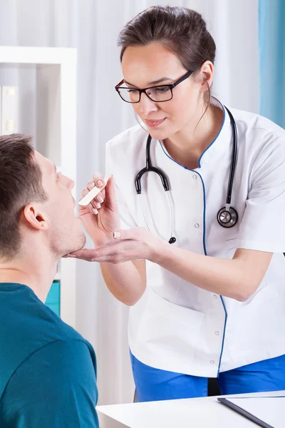 Doctor examining throat of the patient — Stock Photo, Image