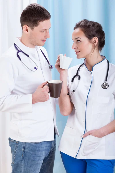 Young doctors drink coffee and talk — Stock Photo, Image