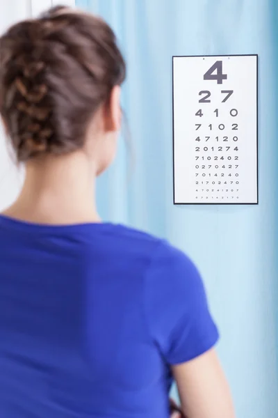 Jonge vrouw doet oog proeven — Stockfoto