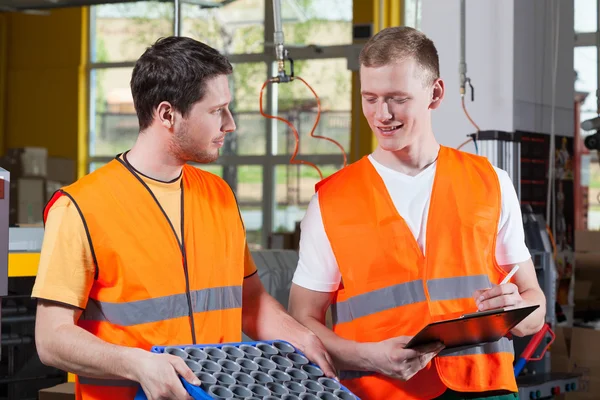 Factory workers in orange protective vest — Stock Photo, Image