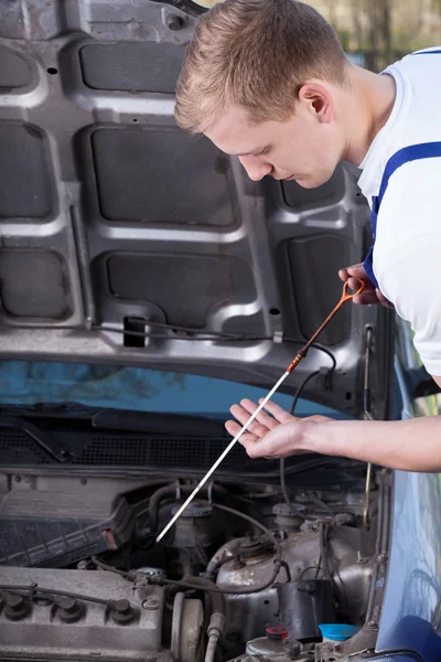 Mechanic checking oil level — Stock Photo, Image