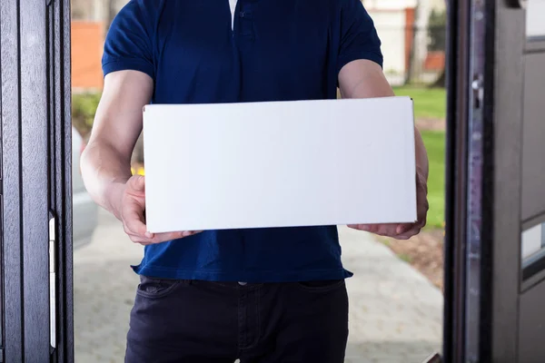 Courier standing in front of house — Stock Photo, Image
