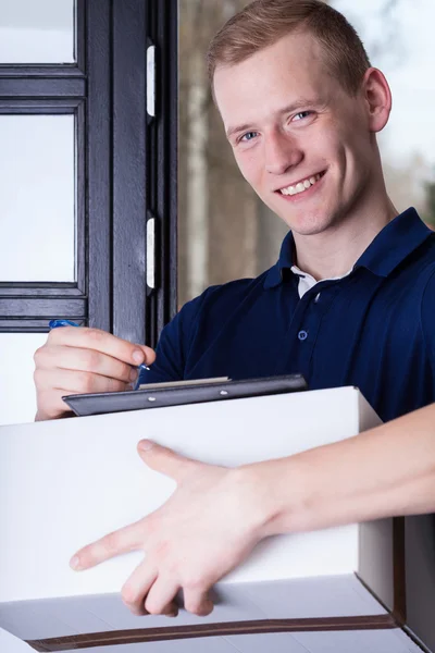 Lächelnder Kurier unterschreibt Dokumente — Stockfoto