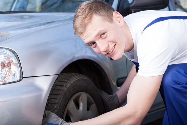 Auto mechanic checks a car tire — Stock Photo, Image