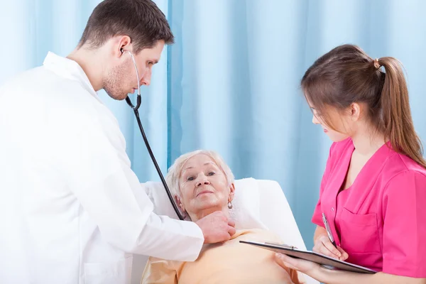 Doctor examining elderly lady — Stock Photo, Image