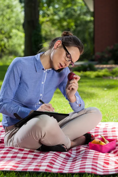 Frau macht sich Notizen im Park — Stockfoto