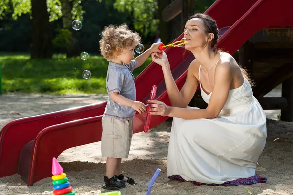 Mom and boy making bubbles — Stock Photo, Image