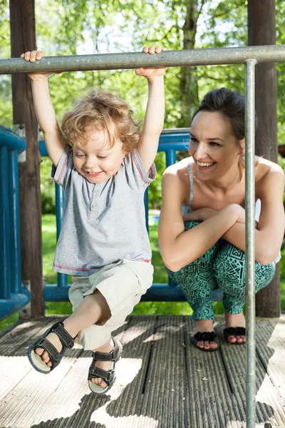 Jongen swingen op monkey bars — Stockfoto