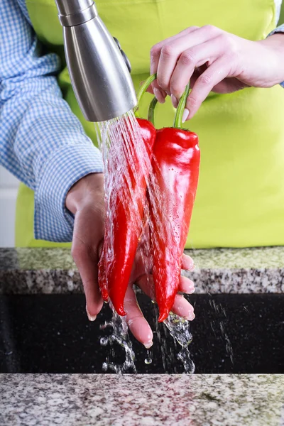 Huisvrouw wassen paprika 's — Stockfoto