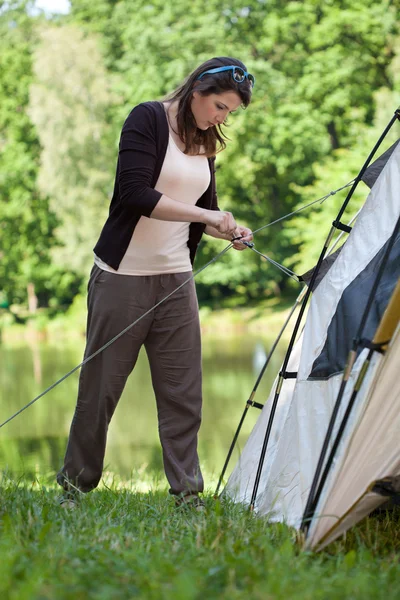 Девушка пытается поставить палатку — стоковое фото