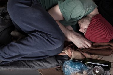 evsiz bir karton üzerinde uyuyor