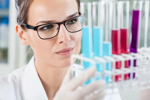 Woman looking at test tubes — Stock Photo, Image