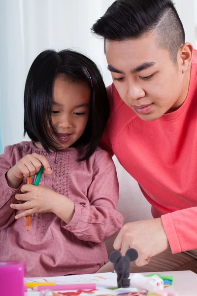 Asian girl and dad drawing together — Stock Photo, Image