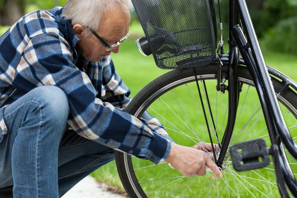 Homem reparando roda de bicicleta — Fotografia de Stock