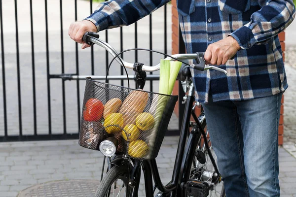 Mann und Fahrradkorb voller Lebensmittel — Stockfoto
