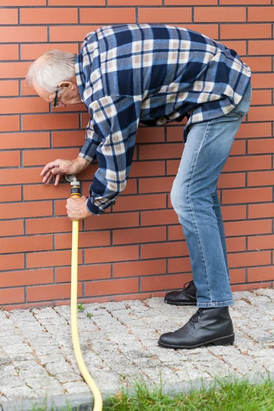 Man repairing leaky garden hose spigot — Stock Photo, Image