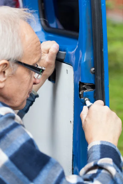 Close-up of a man repairing car door — Stock Photo, Image