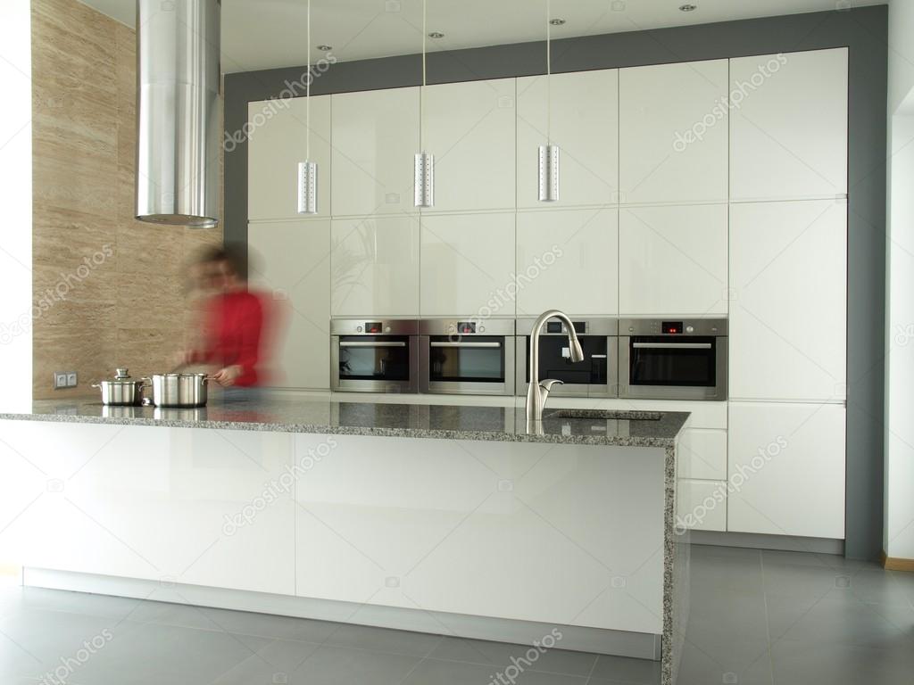 Female cooking in modern kitchen interior