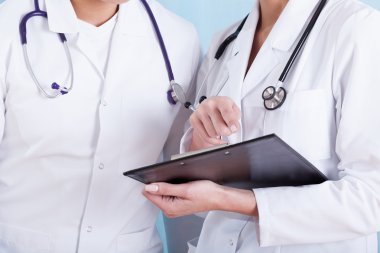 Doktorların tıbbi Beyaz önlük stetoskoplar ve Pano
