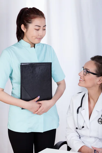 Caucasian female doctor and Asian assistant — Stock Photo, Image