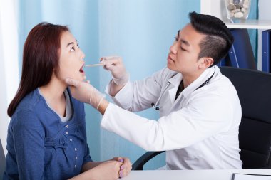 Asyalı doktor kadın hastasını muayene
