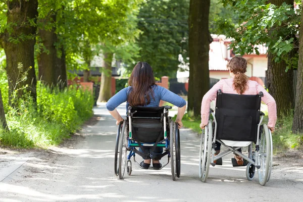 Dwie kobiety na wózki inwalidzkie w parku — Zdjęcie stockowe