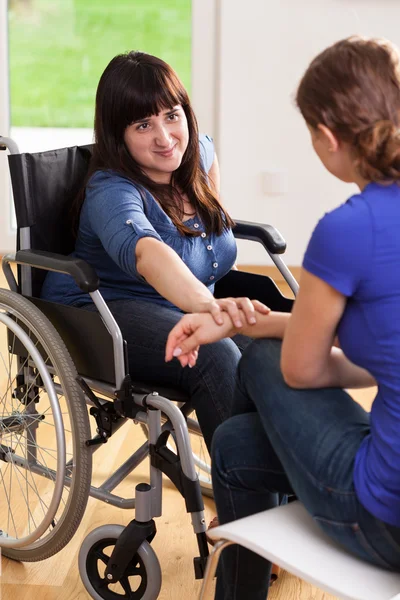 Girl on wheelchair talking with female friend — Stock Photo, Image