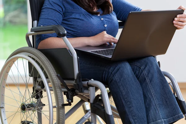 Postižené ženě na vozíku pomocí přenosného počítače — Stock fotografie