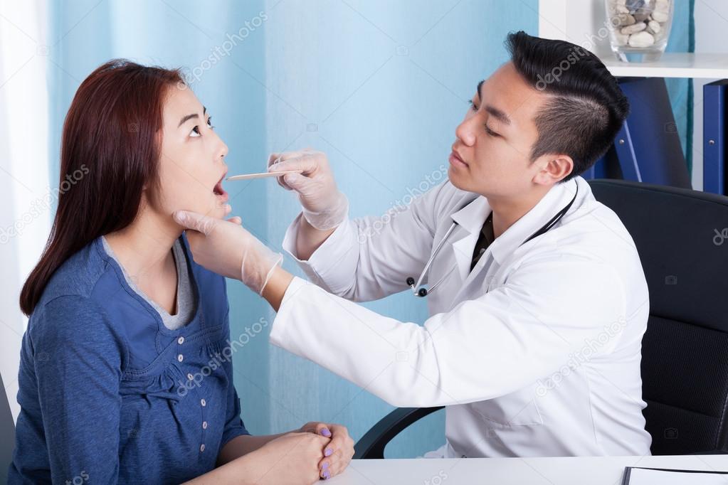 Asian doctor examining his female patient