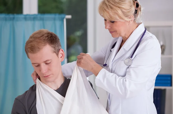 Arts zetten sling aan patiënt — Stockfoto