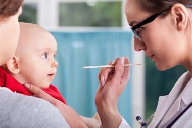 Doktor muayene bebek spatula ile