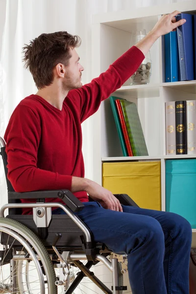 Niepełnosprawny mężczyzna biorąc książki — Zdjęcie stockowe
