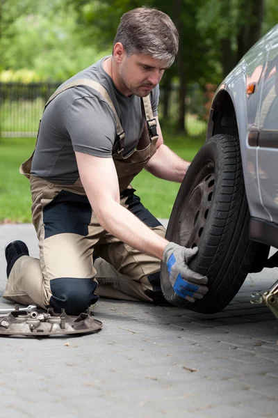 Hombre cambiando la rueda del coche — Foto de Stock