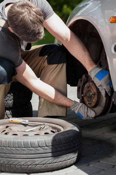 L'uomo che cambia i freni di un'auto — Foto Stock