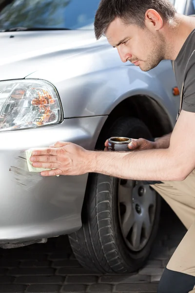 Homme appliquant du vernis pour enlever les rayures — Photo