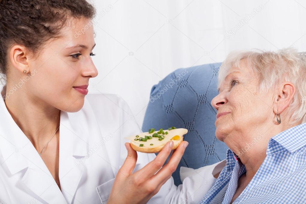 Nurse feeding elderly woman