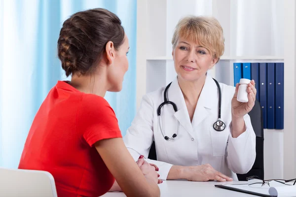 Mature Lady doctor showing patient medication — Stock Photo, Image