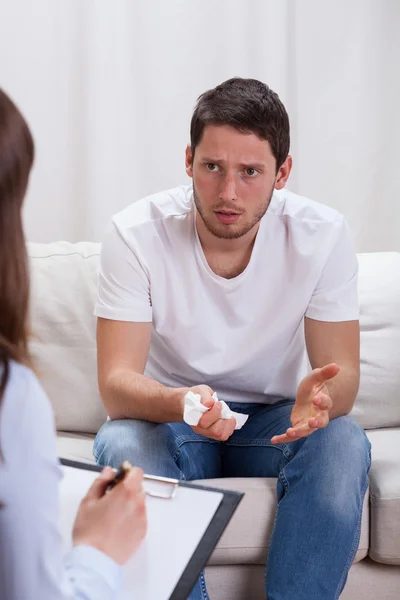 Depressiver Mann sitzt auf Psychotherapeutensofa — Stockfoto