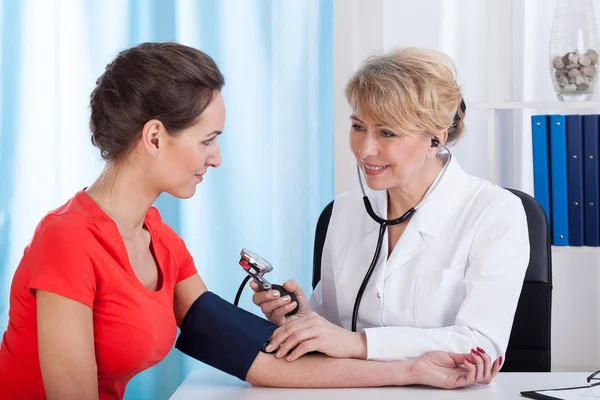 The doctor measures the pressure of woman Royalty Free Stock Photos