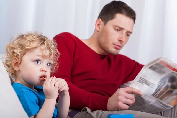 Ребенок с папой читает газету — стоковое фото