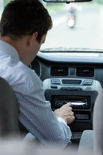 Homme changer de chanson dans la voiture — Photo