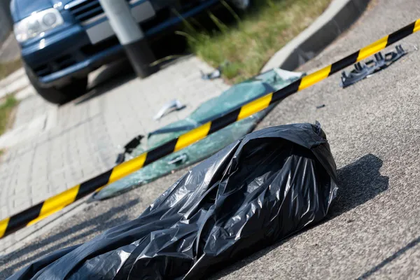 Corpse in bag after car accident — Stock Photo, Image