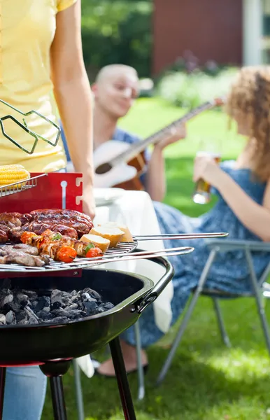 People grilling, playing guitar and singing — Stock Photo, Image