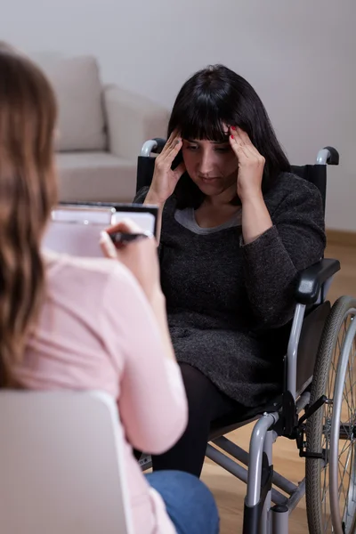 Woman on wheelchair talking with therapist — Stock Photo, Image