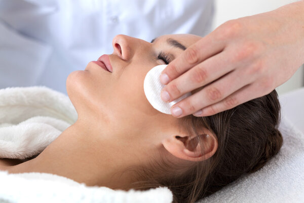 Woman during facial cleansing in spa
