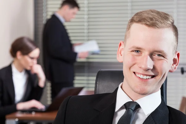 Uśmiechający się biznesmen i jego współpracowników — Zdjęcie stockowe