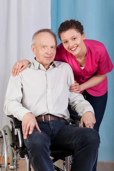 Enfermeira ao lado dos deficientes numa cadeira de rodas — Fotografia de Stock
