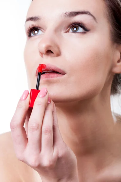 Женщина красит губы красной помадой — стоковое фото
