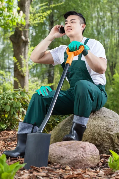 Gardener resting, talking on the phone — Stock Photo, Image