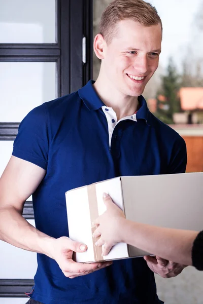 Cheerful courier giving delivery — Stock Photo, Image